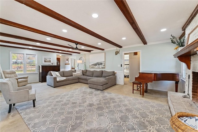 carpeted living room featuring ceiling fan, crown molding, beamed ceiling, and a brick fireplace