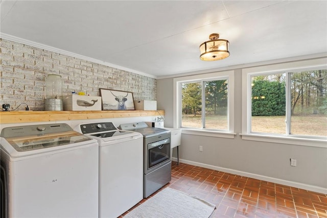 washroom featuring sink, independent washer and dryer, and crown molding