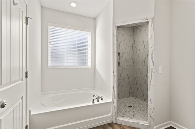 bathroom featuring hardwood / wood-style floors and separate shower and tub