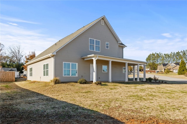 back of property with covered porch and a yard