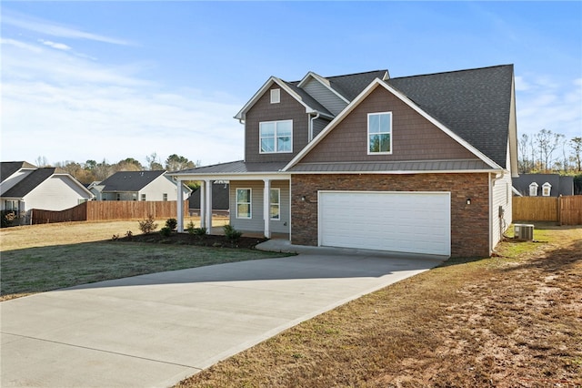 view of front of home featuring central AC unit, a garage, and a front lawn