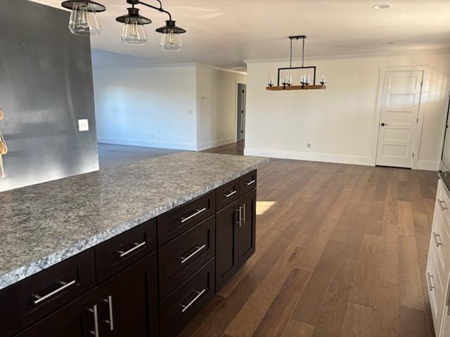 kitchen featuring white cabinetry, dark wood-type flooring, pendant lighting, and light stone counters