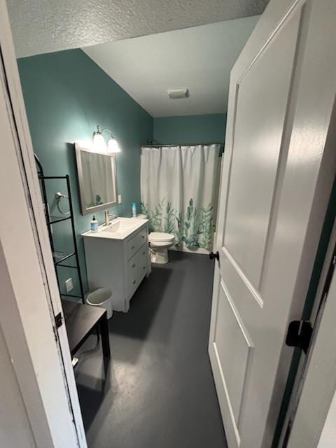 bathroom featuring a textured ceiling, vanity, toilet, and concrete floors