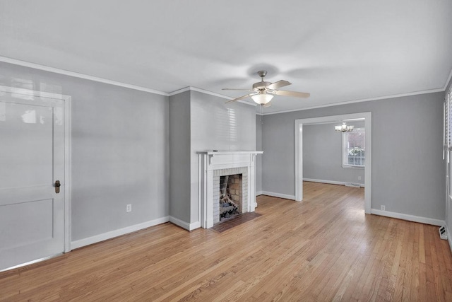 unfurnished living room with a brick fireplace, ceiling fan with notable chandelier, ornamental molding, and light hardwood / wood-style floors