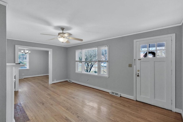 foyer featuring ceiling fan with notable chandelier, plenty of natural light, light hardwood / wood-style flooring, and ornamental molding