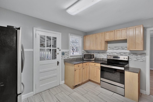 kitchen with tasteful backsplash, light brown cabinetry, and stainless steel appliances