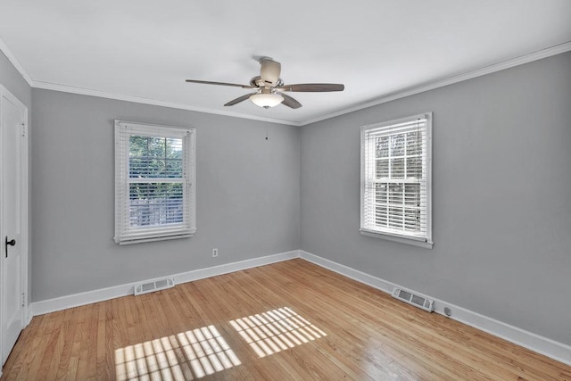 empty room with plenty of natural light, ornamental molding, and light hardwood / wood-style flooring