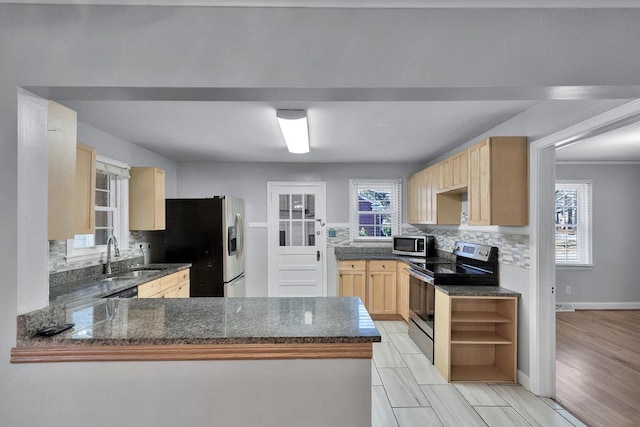 kitchen featuring kitchen peninsula, stainless steel appliances, decorative backsplash, light brown cabinets, and sink