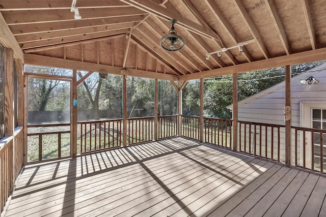 unfurnished sunroom featuring vaulted ceiling and a healthy amount of sunlight