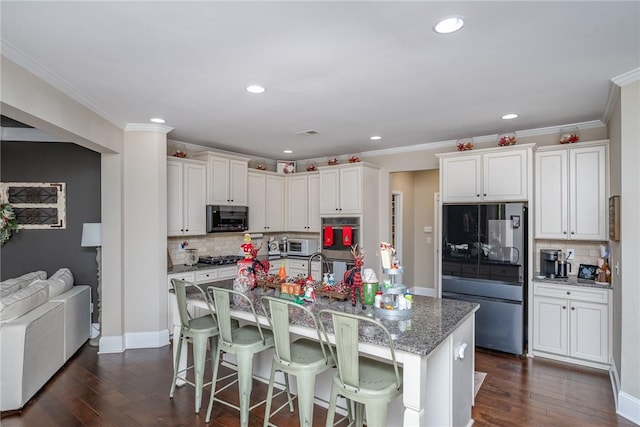 kitchen featuring white cabinets, dark hardwood / wood-style floors, light stone countertops, and stainless steel appliances