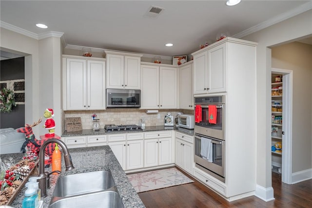 kitchen with white cabinets, appliances with stainless steel finishes, dark wood-type flooring, and sink