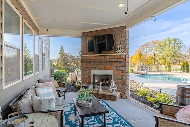 sunroom featuring an outdoor stone fireplace