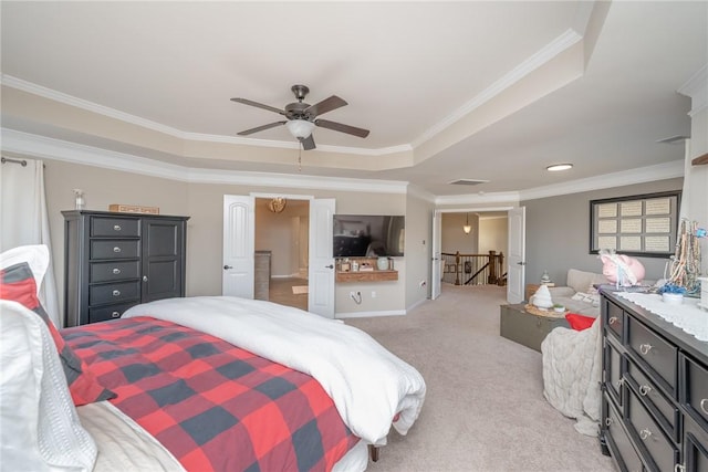 carpeted bedroom featuring a raised ceiling, ceiling fan, and ornamental molding