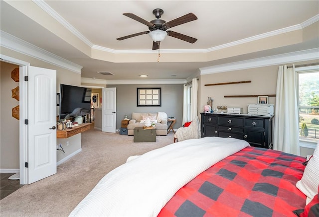 carpeted bedroom with ceiling fan, ornamental molding, and a tray ceiling