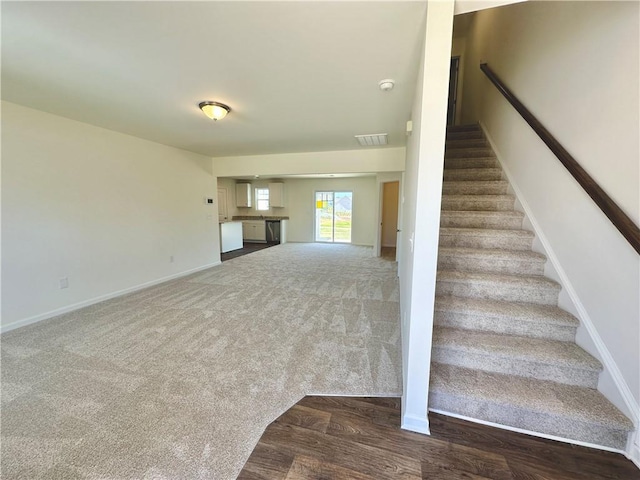 staircase featuring carpet