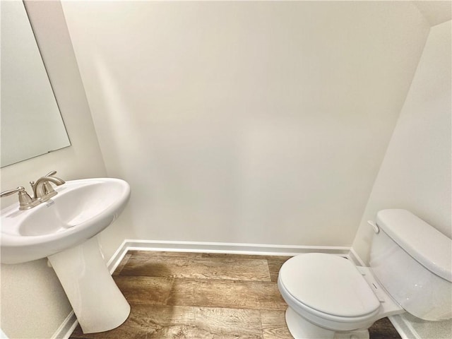 bathroom featuring hardwood / wood-style flooring and toilet