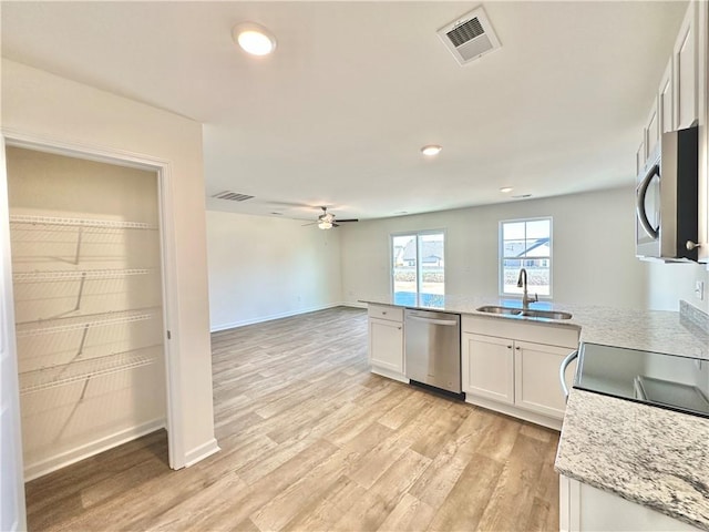 kitchen with sink, white cabinetry, light wood-type flooring, ceiling fan, and stainless steel appliances