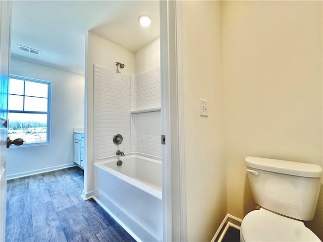 full bathroom featuring hardwood / wood-style flooring, vanity, shower / bathtub combination, and toilet