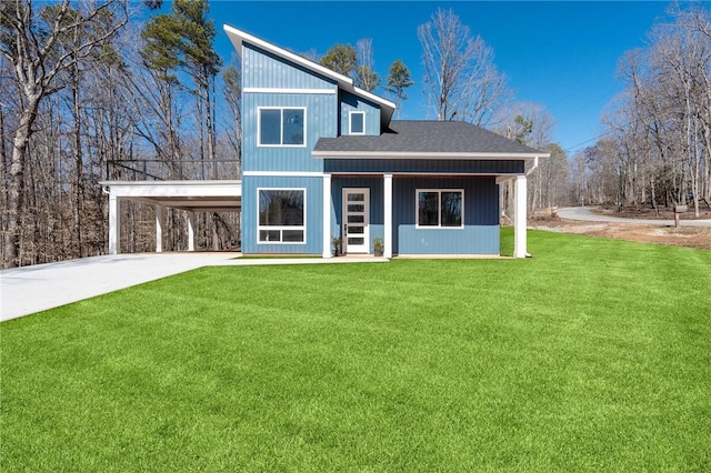 view of front of home featuring driveway, an attached carport, a front lawn, and a shingled roof