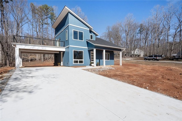 view of front facade featuring covered porch, an attached carport, and concrete driveway