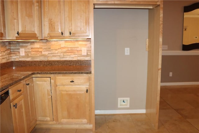 kitchen with dishwasher, light brown cabinets, backsplash, and dark stone countertops