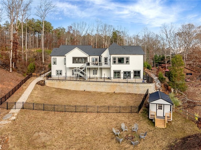 rear view of house featuring a wooden deck and an outdoor structure