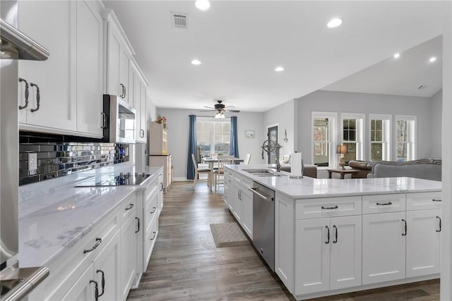 kitchen with white cabinets, appliances with stainless steel finishes, and a wealth of natural light