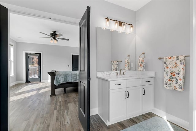 bathroom with hardwood / wood-style floors, ceiling fan, and vanity