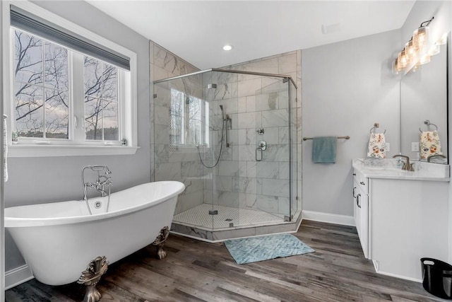 bathroom featuring plus walk in shower, vanity, and hardwood / wood-style flooring