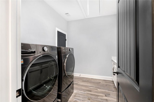 laundry area with light hardwood / wood-style floors and separate washer and dryer