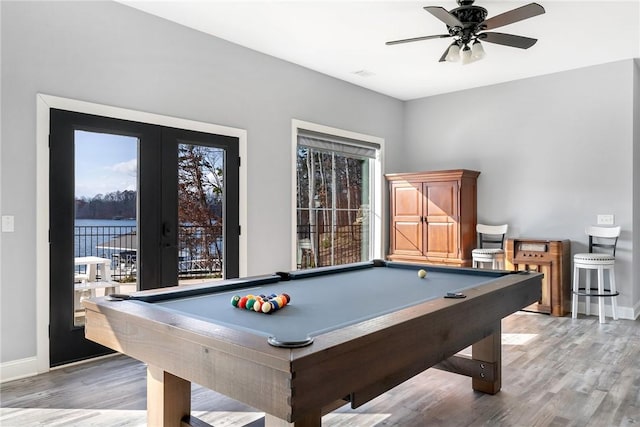 recreation room featuring ceiling fan, a water view, dark wood-type flooring, and billiards