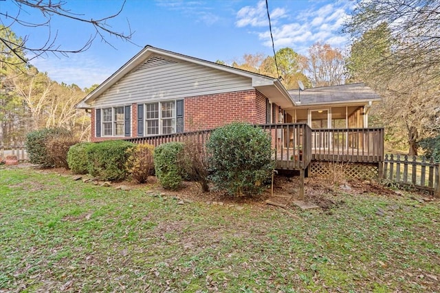 view of home's exterior featuring a lawn and a wooden deck