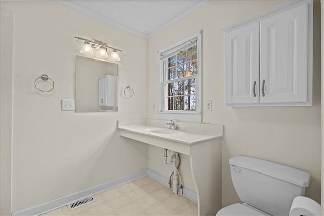 bathroom with crown molding, sink, and toilet