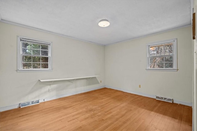 unfurnished room featuring hardwood / wood-style floors and ornamental molding