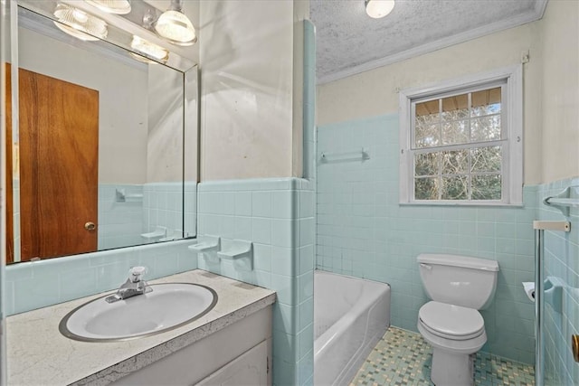 bathroom featuring a washtub, crown molding, a textured ceiling, toilet, and tile walls