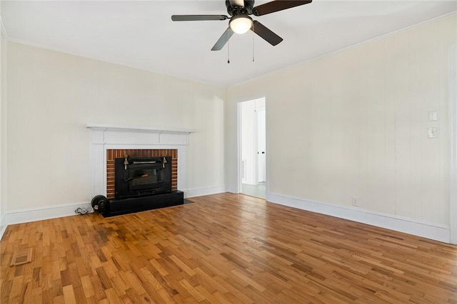 unfurnished living room with ceiling fan, light wood-type flooring, crown molding, and a brick fireplace