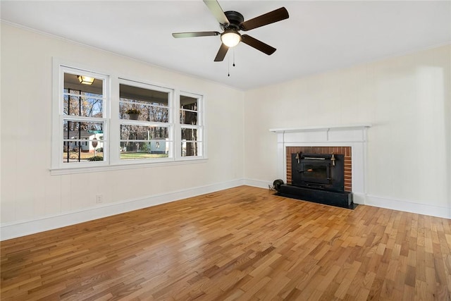 unfurnished living room with a fireplace, light hardwood / wood-style flooring, ceiling fan, and crown molding