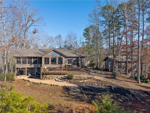 rear view of house with a sunroom and a deck