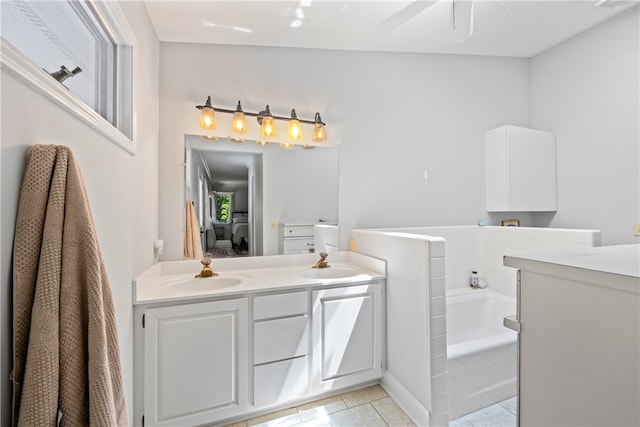 bathroom with a bathing tub, ceiling fan, tile patterned flooring, and vanity