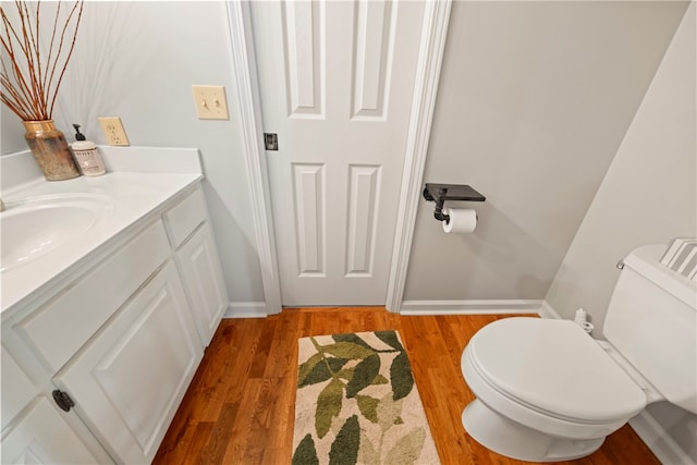 bathroom featuring toilet, vanity, and hardwood / wood-style flooring