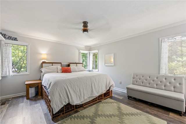 bedroom with multiple windows, ceiling fan, dark hardwood / wood-style flooring, and crown molding