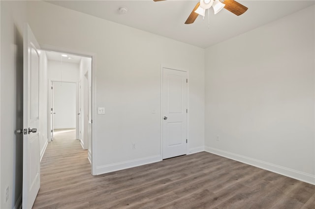 unfurnished bedroom featuring hardwood / wood-style flooring, ceiling fan, and a closet