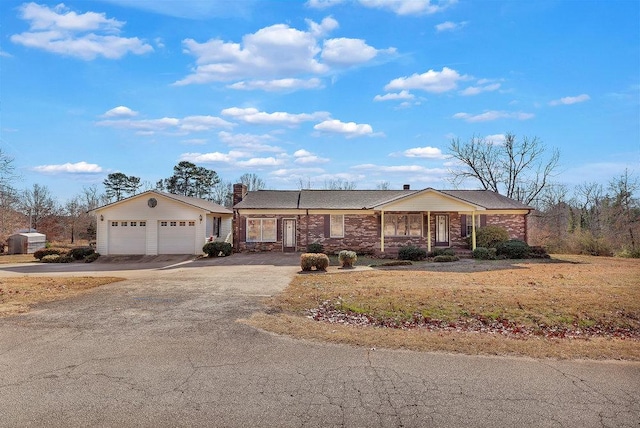 ranch-style home featuring an outbuilding, covered porch, and a garage