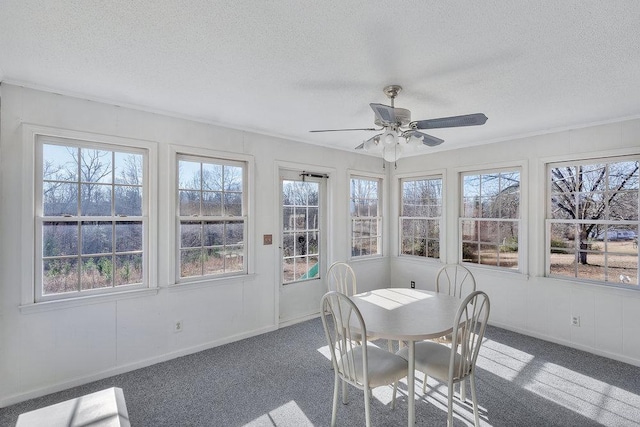 sunroom / solarium featuring plenty of natural light and ceiling fan