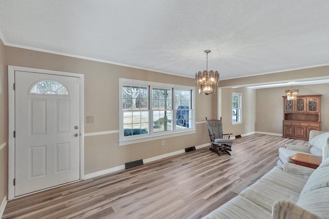 entrance foyer featuring plenty of natural light, light wood-type flooring, and an inviting chandelier