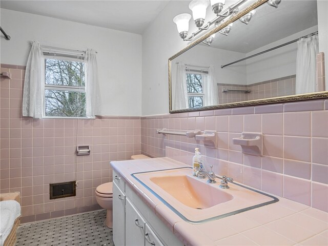 bathroom with plenty of natural light, tile walls, and vanity