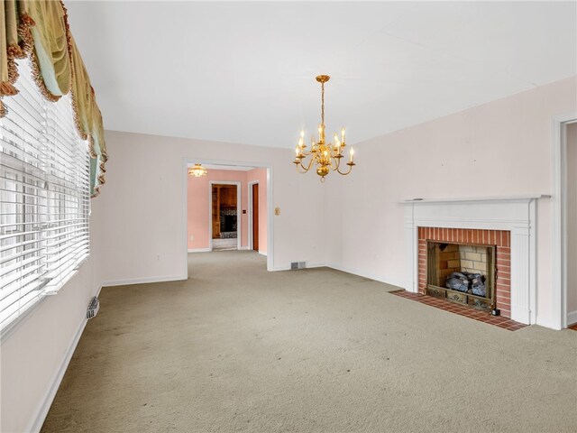 unfurnished living room with a fireplace, carpet, and an inviting chandelier