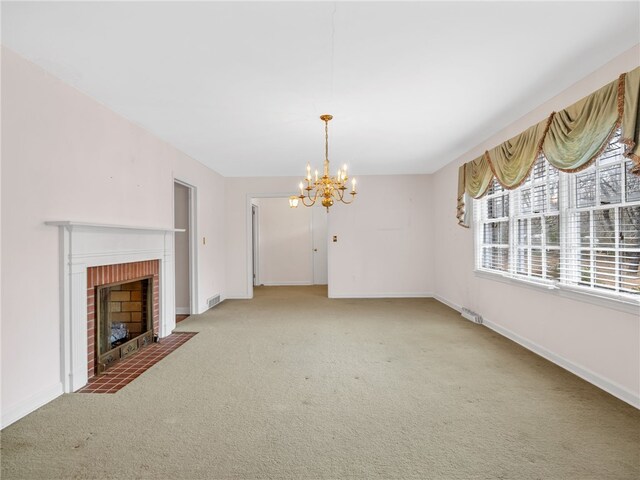 unfurnished living room with a fireplace, carpet floors, and a notable chandelier