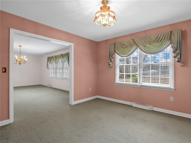 carpeted empty room with a chandelier