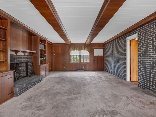 unfurnished living room featuring light carpet, a fireplace, and brick wall